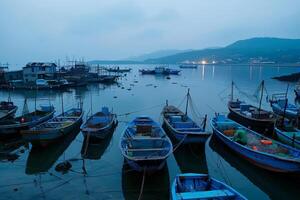 pesca villaggio a alba, Barche ormeggiato con pescatori preparazione reti, tranquillo, calmo ancora occupato mattina foto