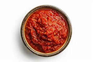ciotola di vivace rosso pomodoro salsa isolato su un' bianca sfondo, superiore Visualizza, Perfetto circolare forma foto