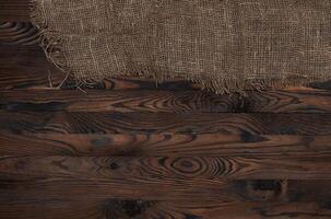 vecchio tela ruvida tessuto tovagliolo su Marrone di legno sfondo, superiore Visualizza foto