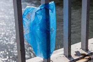 blu plastica Borsa sospeso su il ringhiera di elisabetta ponte al di sopra di donau fiume nel budapest. spazzatura nel il città. ambientale inquinamento concetto. ecologico disastro, catastrofe. selettivo messa a fuoco foto