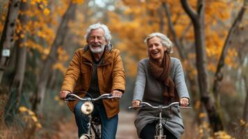 un' coppia nel loro d'oro anni pedale lato di lato su loro accoppiamento biciclette sorridente e ridendo come essi godere un' senza fretta cavalcata foto