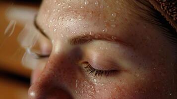 avvicinamento di un' womans viso perline di sudore formatura su sua fronte come sua pelle purghe tossine nel il sauna. foto