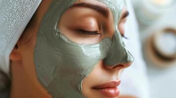 l'applicazione un' naturale argilla maschera per il viso ricco nel minerali e disintossicante proprietà. foto