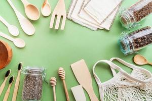 borsa ecologica a zero rifiuti e strumenti in legno vista dall'alto su sfondo verde foto