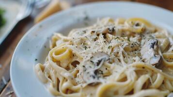 appena fatto pasta sormontato con un' cremoso aglio e fungo salsa e un' generoso spruzzatina di parmigiano formaggio foto