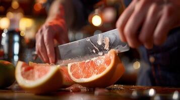 un' avvicinamento di un' barman utilizzando un' grande coltello per sapientemente fetta Aperto un' grande rosa pomelo quale volontà essere Usato nel un' rinfrescante agrume e Vodka cocktail foto