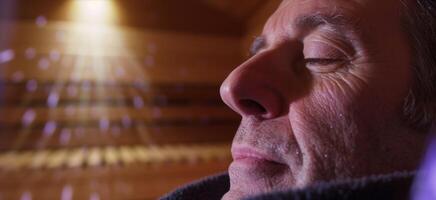 un' uomo meditativamente respirazione nel il caldo aria di un infrarosso sauna promozione rilassamento e allargato polmone capacità. foto