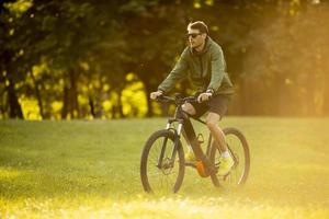 giovane in sella a ebike nel parco foto