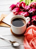 tazza di caffè e tulipani rosa foto