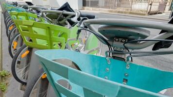 riga di colorato pubblico noleggio biciclette con cesti nel urbano ambientazione, concetto di eco amichevole trasporto, sostenibile città vita, e verde pendolarismo foto