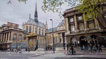 primavera Visualizza di il iconico palais de giustizia con pedoni e ciclista, incorniciato di gemmazione alberi, Parigi, Francia, aprile 14, 2024, ideale per viaggio e architettura temi foto