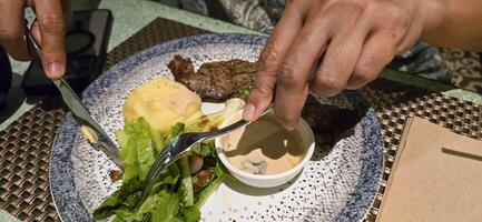 Manzo nuovo York striscia lombo bistecca o controfiletto bistecca servito con patate, e fungo salsa e insalata su piatto foto