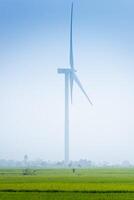 Visualizza di turbina verde energia elettricità, mulino a vento per elettrico energia produzione, vento turbine generando elettricità su riso campo a phan suonò, ninh gio Provincia, Vietnam foto