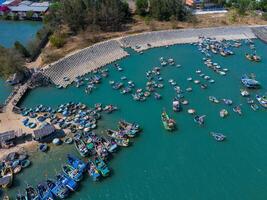 aereo Visualizza di posizione un pesca villaggio, Vung tau città. un' pesca porta con tsunami protezione calcestruzzo blocchi. paesaggio urbano e tradizionale Barche nel il mare. foto