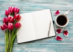 quaderno, tazza di caffè e tulipani rosa foto