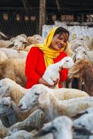 vietnamita donna con agnello su un' campagna, un' pecora azienda agricola nel il steppa zona nel ninh gio Provincia, Vietnam. foto