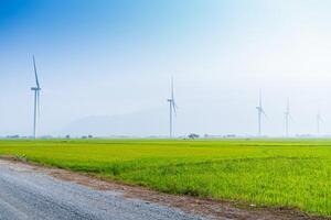 Visualizza di turbina verde energia elettricità, mulino a vento per elettrico energia produzione, vento turbine generando elettricità su riso campo a phan suonò, ninh gio Provincia, Vietnam foto