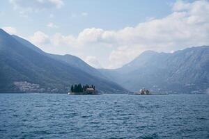 isola di st. Giorgio nel il baia di kotor contro il fondale di un' montagna gamma nel un' leggero foschia. montenegro foto