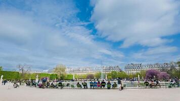 visitatori godendo un' soleggiato giorno a un' vivace pubblico parco con fioritura alberi, fontane, e parigino architettura nel il sfondo, Perfetto per primavera temi 15 aprile 2024, Parigi, Francia foto