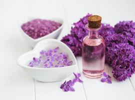 olio essenziale e sale marino con fiori di lillà foto