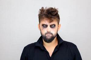 ritratto di un' uomo in piedi su un' bianca sfondo con in stile non morto trucco per tutti santi Halloween foto