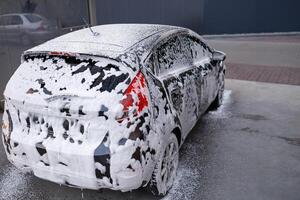 c'è schiuma In arrivo via il macchina. un' auto a un' se stesso servizio auto lavare. foto