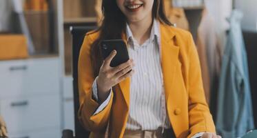 ritratto bellissimo Sorridi asiatico progettista donna uso computer nel sarto tessuto moda piccolo attività commerciale in linea officina. giovane proprietario avviare imprenditore. creativo ragazza tessile indumento pmi attività commerciale concetto foto