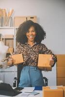 startup piccola impresa imprenditore di freelance donna asiatica che usa un laptop con scatola allegro successo donna asiatica la sua mano alza la scatola di imballaggio di marketing online e consegna sme idea concept foto
