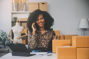 avviare una piccola impresa imprenditoriale o una donna asiatica freelance che utilizza un laptop con scatola, giovane donna asiatica di successo con la mano alzata, scatola di imballaggio e consegna di marketing online, concetto di PMI. foto