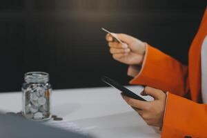 donna è fare in linea acquisti. ragazza è fare shopping utilizzando Telefono e credito carta a casa. foto