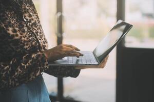 il ritratto di una giovane donna asiatica libera professionista sta lavorando sul tablet del computer in un ufficio moderno. fare un rapporto di analisi contabile dati di investimento immobiliare, concetto di sistemi finanziari e fiscali. foto