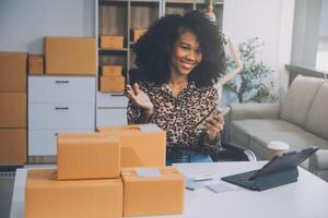 avviare una piccola impresa imprenditoriale o una donna asiatica freelance che utilizza un laptop con scatola, giovane donna asiatica di successo con la mano alzata, scatola di imballaggio e consegna di marketing online, concetto di PMI. foto