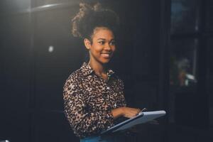 il ritratto di una giovane donna asiatica libera professionista sta lavorando sul tablet del computer in un ufficio moderno. fare un rapporto di analisi contabile dati di investimento immobiliare, concetto di sistemi finanziari e fiscali. foto