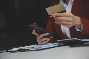 mano Tenere credito carta e utilizzando il computer portatile. donna d'affari o imprenditore Lavorando a partire dal casa. in linea acquisti, commercio elettronico, Internet bancario, la spesa i soldi, opera a partire dal casa concetto foto