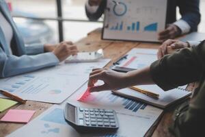 conferenza di lavoro, riunione del team di lavoro presente, colleghi investitori che discutono nuovi dati del grafico finanziario del piano sul tavolo dell'ufficio con laptop e tablet digitale, finanza, contabilità, investimenti. foto