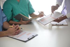 medico squadra incontro in giro tavolo nel moderno ospedale foto