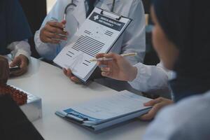 squadra di medico personale avendo mattina incontro nel sala riunioni. medici e infermieri guardare a digitale tavoletta. foto