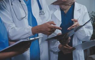 qualità assistenza sanitaria è tutti di mettendo il paziente a il centro. tiro di un' gruppo di medico professionisti avendo un' discussione nel un' Ospedale. foto