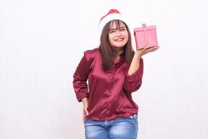 ritratto foto di bellissimo allegro anziano asiatico ragazza trasporto regalo scatola nel Natale Santa Claus cappello moderno brillante rosso camicia attrezzatura sinistra mano sollevamento scatola su bianca sfondo per promozione ,pubblicità