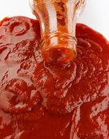 pomodoro salsa . bicchiere bottiglia con ketchup. ketchup è scrosciante su di il collo di un' bicchiere bottiglia. foto