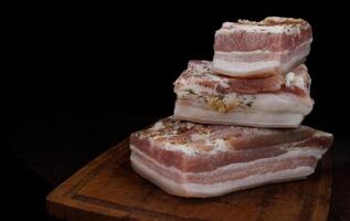 appetitoso salato lardo con strati di carne con aglio e erbe aromatiche. delizioso lardo su un' di legno taglio tavola. foto