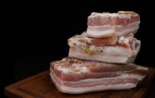 appetitoso salato lardo con strati di carne con aglio e erbe aromatiche. delizioso lardo su un' di legno taglio tavola. foto