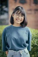 adolescente asiatico a trentadue denti faccia sorridente in piedi all'aperto foto