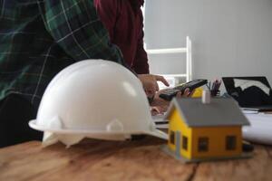 costruzione e struttura concetto di ingegnere o architetto incontro per progetto Lavorando con compagno e ingegneria utensili su modello edificio e planimetria nel Lavorando luogo, contrarre per tutti e due aziende. foto