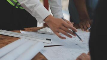 costruzione e struttura concetto di ingegnere o architetto incontro per progetto Lavorando con compagno e ingegneria utensili su modello edificio e planimetria nel Lavorando luogo, contrarre per tutti e due aziende. foto