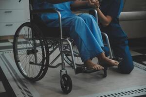 medico dando speranza. vicino su tiro di giovane femmina medico pendente inoltrare per sorridente anziano signora paziente Tenere sua mano nel palme. donna custode nel bianca cappotto supporto incoraggiando vecchio persona foto