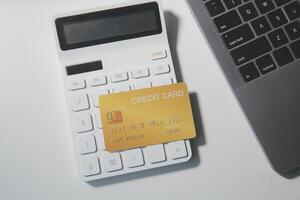 calcolatrice su un' buio sfondo, plastica carte e banconote foto