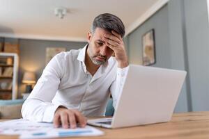 bello uomo Lavorando su il computer portatile. attività commerciale uomo occupato Lavorando su il computer portatile computer a ufficio. uomo d'affari seduta a luminosa moderno opera stazione e digitando su il computer portatile foto