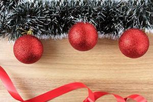 fondo in legno, decorazioni natalizie con palline e regali, rami di albero decorativi foto