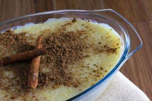 budino di riso con cannella su tavola di legno foto